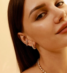 Close-up of elegant gold plated micro-paved cubic zirconia ear cuff worn on model's ear
