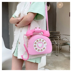 Detailed view of creative pink telephone shaped crossbody bag with heart dial design