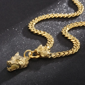 Detailed macro shot of golden wolf head charms on a Cuban link chain with black background