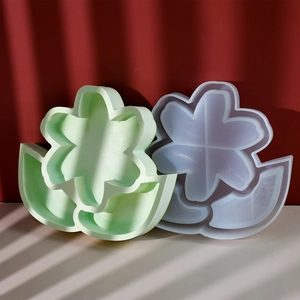 Primer plano de moldes de silicona con forma de flor y base de hoja bajo efectos de sombras