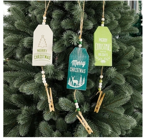Close-up of wooden Christmas tree hanging tags with Merry Christmas print and beads