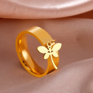 Macro shot of a gold-plated stainless steel dragonfly charm ring on silk fabric