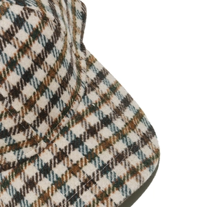 Close-up of houndstooth wool fabric texture and stitching on a vintage baseball cap