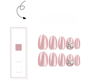 Detail of pink cat eye press-on nails with 3D floral rhinestones and pearls