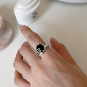 Detail of 925 silver ring featuring a black onyx oval face and white tulip motif
