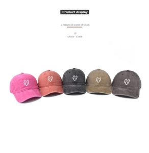 Detailed display of vintage washed cotton baseball caps with embroidered heart logos