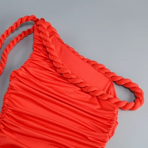 Detail of red ruched party dress featuring a handmade braided shoulder strap and slim fit