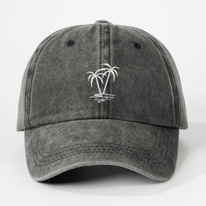 Close-up of embroidered white palm tree on washed dark grey cotton baseball cap texture