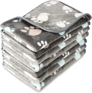 Detail of stacked grey flannel pet blankets with colorful paw prints in a pack of six