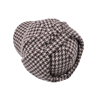 Dettaglio del tessuto in lana pied-de-poule su un cappello vintage con paraorecchie