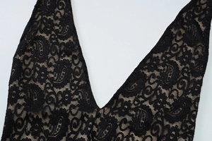Macro shot of black lace floral texture and intricate V-neck strap detailing on bodysuit
