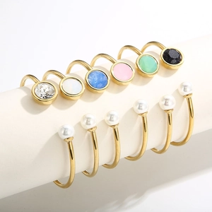 Bracelets joncs dorés minimalistes avec cristaux colorés et perles sur présentoir blanc