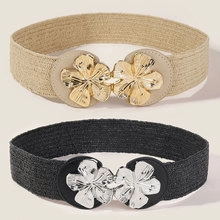 Detail of beige and black elastic belts with decorative gold and silver flower buckles