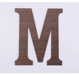 Detailed close-up of dark wood grain texture on a decorative serif letter M wall ornament
