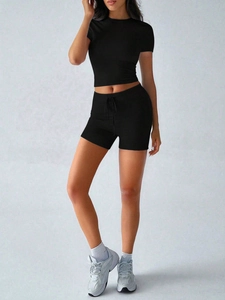 Détail d'ensemble de yoga noir avec short à cordon taille haute et tissu respirant