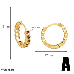 Détail de boucles d'oreilles en cuivre doré avec zircons colorés et design en nid d'abeille