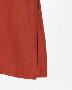Gros plan détaillé de la fente latérale et de la texture en lin d'une robe brun rouge