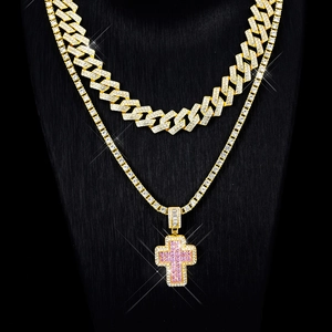 Detail of pink crystal cross pendant on gold cuban and tennis chain set for hip hop style