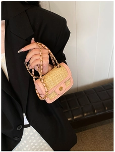Detail of pink PU leather trim and woven straw texture with a metal flower clasp