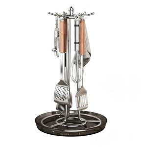Rotating stainless steel kitchen utensil holder with wooden handles on a white background