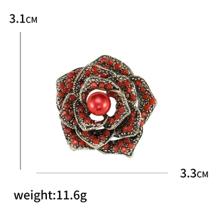 Vintage gold rose brooch with red pearls and turquoise accents on white background