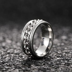 Macro detail of silver spinner ring with rotating Cuban chain and punk texture