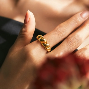 Elegant gold twisted croissant ring with glossy finish and minimalist irregular metal design