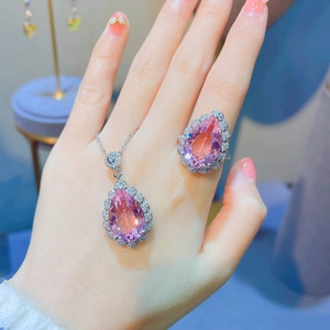Macro detail of pear-cut pink morganite jewelry set with teardrop pendant and ring