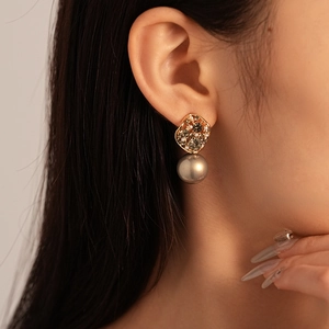 Detailed close-up of a vintage-style earring with crystals and a grey pearl pendant