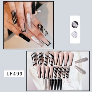 Detail of coffin-style press-on nails featuring marble textures and silver glitter accents