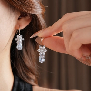 Elegant silver teardrop flower earrings with cubic zirconia on female model