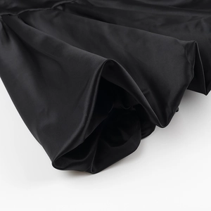 Gros plan sur le tissu en maille noire montrant une texture lisse et des plis élégants