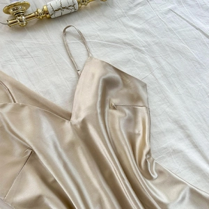 Elegant champagne gold satin V-neck chemise sleepwear with adjustable straps on white linen