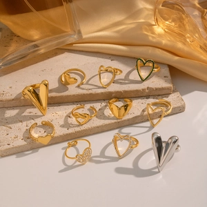Elegant gold and silver heart-shaped diamond rings displayed on a stone surface