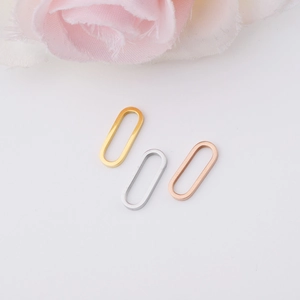 Macro shot of oval egg-shaped earring clasps in gold, silver, and rose gold finishes