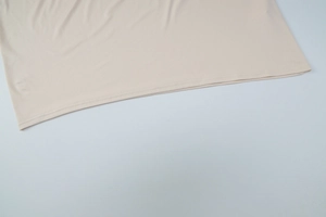 Gros plan de l'ourlet de robe beige avec une couture plate à double aiguille
