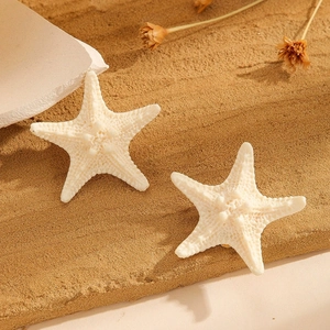 Women's ocean style starfish hair clips on sand with shells and vintage beach vibes