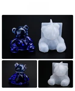 Macro detail of geometric bear silicone mold and finished blue resin craft on black background