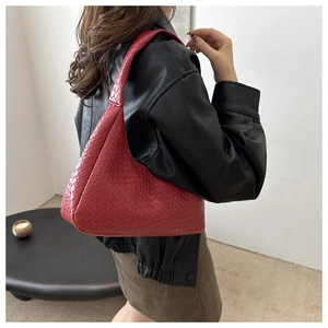 Close-up of red woven leather shoulder bag styled with a chic black leather coat