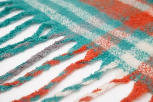 Detailed close-up showing thick woven plaid scarf texture with blue and orange fringes