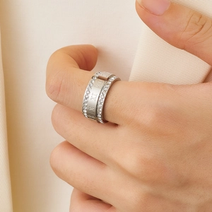 Detail of silver dual-band ring with Roman numeral engraving and shimmering zircon inlay