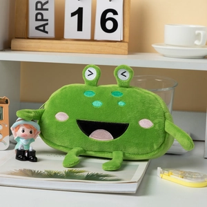 Funny green frog plush pencil case for stationery storage on a white desktop setup