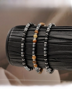 Three-piece set of men's beaded bracelets featuring lava stone and jasper on a display
