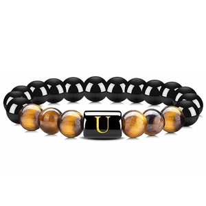 Détail du bracelet en perles d'agate noire, oeil de tigre et breloque lettre U dorée