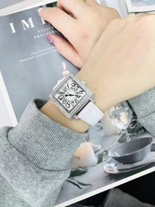 Vista detallada de reloj cuadrado para mujer con diamantes y correa de cuero blanco