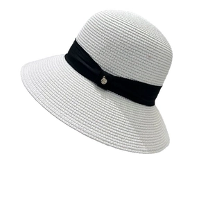 Elegant white straw sun hat with black ribbon and metal buckle for beach vacation