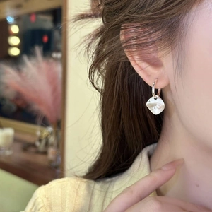 Boucles d'oreilles losanges argentées brossées avec pendentif perle portées par mannequin