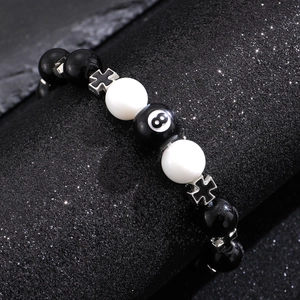 Detailed close-up of obsidian cross bracelet with black 8 billiard bead and silver charms