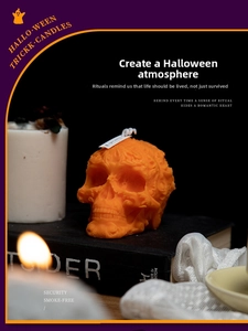 Close-up of bright orange skull-shaped scented candle with intricate embossed patterns