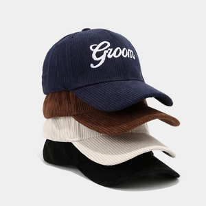 Vertical stack of four corduroy baseball caps in navy, brown, beige and black